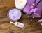 Spa setting with bath salt, orchid , candle, towels and on wooden board top view