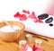 Spa setting with candle, flower red petals, towel and salt