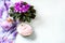 Spa setting with cosmetic cream, bath salt and African violet in flower pot on white wooden table background. Selective focus