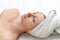 Spa skin care beauty woman wearing wrapped hair towel on a head after beauty treatment, Caucasian woman lying on white sheet