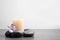 Spa stones, burning candle and freesia flower on table, space for text