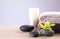 Spa stones with exotic flower, burning candle and fresh towels on wooden table