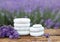 Spa stones, fresh lavender flowers and bath salt on wooden table outdoors