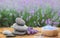 Spa stones, fresh lavender flowers and bath salt on wooden table outdoors, closeup