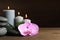 Spa stones, orchid flower, burning candles and bamboo sprout on wooden table. Space for text