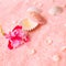 spa tender concept with pink flower fuchsia, seashells on delicate terry texture, closeup