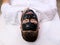 Spa therapy for men receiving facial black mask.