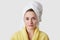 Spa treatments and hygiene concept. Headshot of pleasant looking young woman with healthy pure soft skin, wears white soft towel