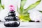 Spa or wellness background with stack of hot stones with water drops for massage and pink flower