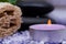 Spa Wellness Concept. Natural Loofah Sponge, stacked Basalt Stones, burning Lavender Tea Light Candle and sprinkled Epsom