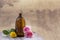 Spa and wellness concept: preparation of essential oil with pink roses, brown bottle of tincture on wooden board with a