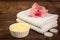 Spa or wellness set. Yellow sea salt in white bowl, candle, towels and pink flowers lily on brown wooden background. Selective