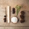 Spa and wellness setting with sea salt, oil essence, cones and candle on wooden background. Fall autumn wellness concept, Relax