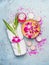 Spa or wellness setting with towel, bamboo leaves , bowl with pink orchid flowers and water , cream, candles and sea salt