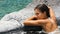 Spa wellness - woman relaxing in hot tub whirlpool jacuzzi at resort