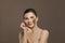 Spa woman with brown scrub on her skin on brown background. Facial treatment, body care and skin care concept