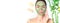 Spa. Young woman applying facial green clay mask in spa salon. Beauty treatments. Skincare