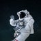 Space man in a suit with a helmet waves his hand and greeting in open space. Hello concept. Astronaut travels