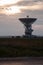 Space radar antenna. Satellite dish at sunset with cloudy sky