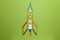Spaceship rocket from stationery on green background. Child imagination, science in elementary school. preschool