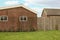 Spacious backyard with lush green grass, wooden fence and climbing plants growing on building wall