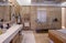 Spacious bathroom with marble walls, walk-in shower, bathtub, mirror and modern fixtures