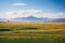 Spacious meadow with grass and the silhouette of mountains in the distance