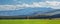 Spacious mountain valley, green field. Rural landscape, panoramic