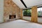 Spacious unfurnished living room interior with high vaulted ceiling and stone trim fireplace