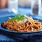 Spaghetti in bolognese sauce on blue plate