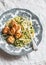 Spaghetti with cheesy chicken meatballs and zucchini noodles. Delicious lunch on a light background