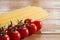 Spaghetti and cherry tomatoes on a wooden table. Homemade food or restaurant. Ingredients for cooking. National Italian healthy