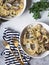 Spaghetti with clams, garlic and parsley in a white bowl, gold appliances on a gray background