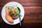 Spaghetti with green curry And a large salmon in a white dish placed on an old wooden table. Thai food