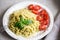 Spaghetti with homemade pesto sauce, basil leaves and  tomatoes