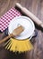 Spaghetti inside a pot next to a wooden fork and a roller.