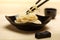 Spaghetti macaroni in black ceramic plate with chopsticks at light bamboo mat