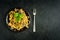 Spaghetti with meat mushroom sauce on a plate with fork on a black concrete background. top view. dark creative mockup with copy