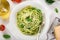 Spaghetti pasta with basil pesto sauce and parmesan cheese on white bowl