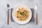 Spaghetti pasta Bolognese with vegetable sauce and cheese. Portion on a plate. Light concrete background