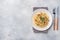 Spaghetti pasta Bolognese with vegetable sauce and cheese. Portion on a plate. Light concrete background. Copy space