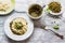 Spaghetti with pesto sauce on white vintage plate, grated cheese, fresh basil leaves and green beans on wooden background