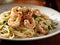 Spaghetti with prawns and parsley on a plate.