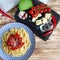 Spaghetti with red sweet pepper and sesame sauce lie on a blue plate on a wooden table