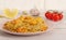 Spaghetti with shrimps with ingredients on a light background in a pink plate. Spaghetti, tomatoes, garlic, lemon. Side