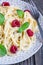 Spaghetti with sour cream, honey and raspberries, vegetarian, vertical