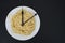 Spaghetti on a white plate, on black background, and clock tongues