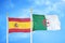 Spain and Algeria two flags on flagpoles and blue cloudy sky