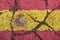 Spain flag on cracked asphalt. The concept of crisis, default, pandemic, conflict, terrorism. Out of focus image