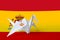 Spain flag depicted on paper origami crane wing. Handmade arts concept